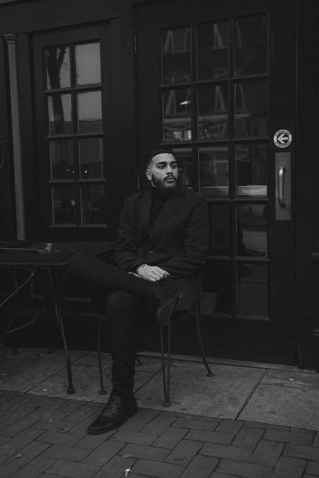 man sitting down at a table with leg folded.